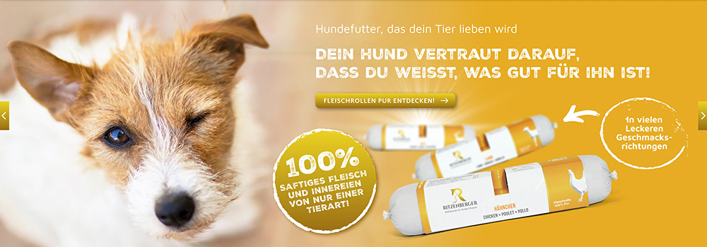 Slider Hundefutter Duo-Roll: Junger hellbraun-weißer Hund schaut nach oben, zwinkert mit einem Auge, knickt rechtes Ohr ab; daneben auf orangenem Hintergrund fliegen Duo-Rolls in den Vordergrund; Beschreibung und Slogan Hundefutter